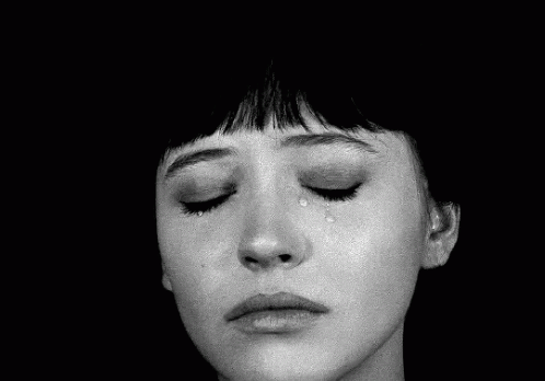 black and white image of a woman's face with her eyes closed