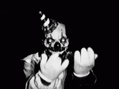 a scary clown holds up a glass with liquid