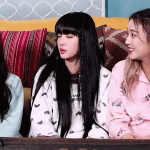 three girls sitting next to each other on a couch