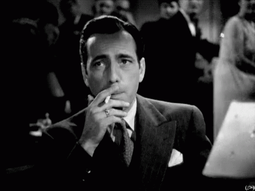 a black and white po of a man with a cigarette in his hand