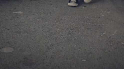 two white shoes that are on a pavement