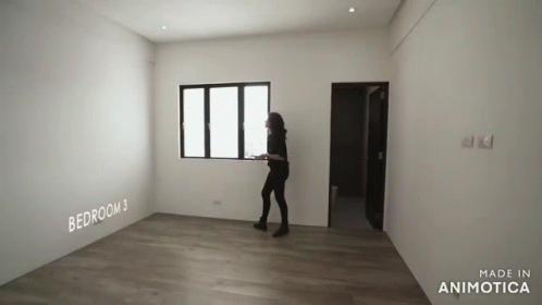 a person standing in an empty room next to the wall