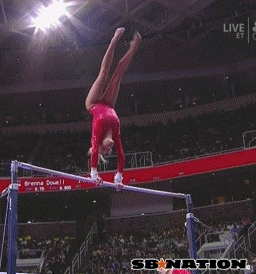 a man performing aerial acrobatics on a beam in a stadium
