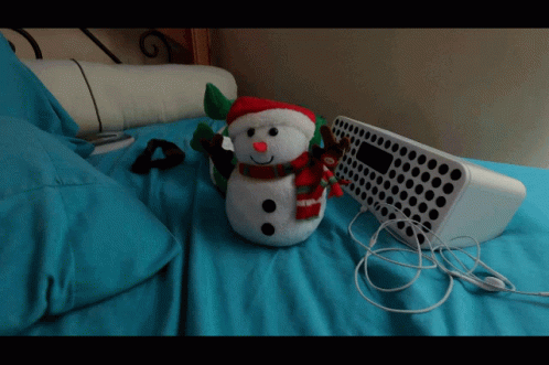 a stuffed snowman sits next to an old computer
