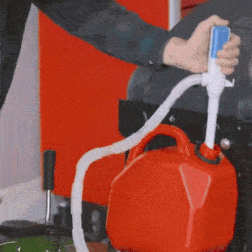 a person pouring an orange liquid into a blue bag