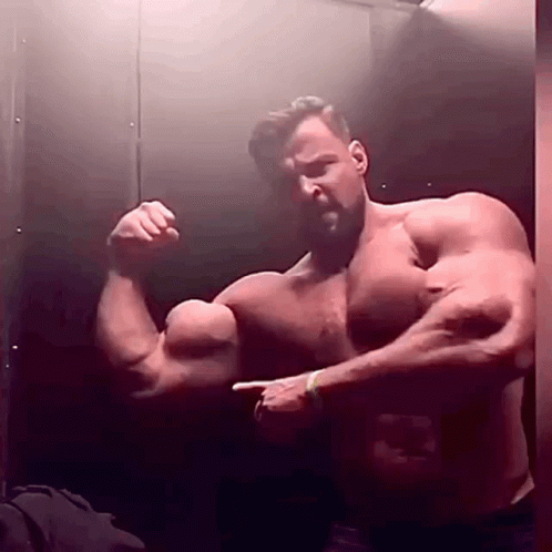 a man showing off his muscles in a bathroom