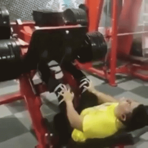 there is a woman lying on the floor with a weights rack