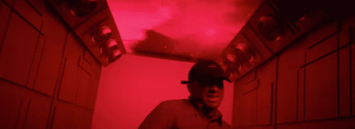 the man is wearing a helmet while walking into a dark room