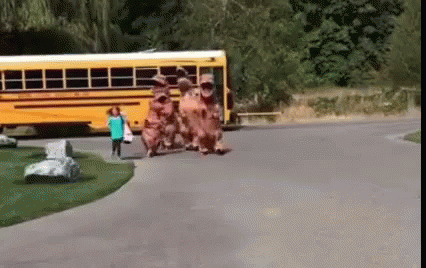 people walking in front of a blue school bus