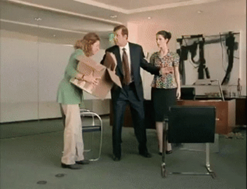 three women in suits and ties shaking hands in an office