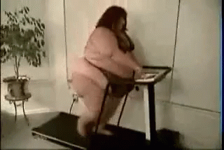 a woman sitting on a desk and using a treadmill