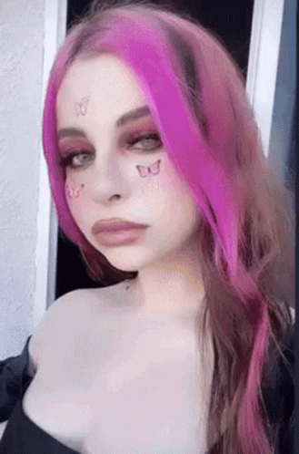 a woman with pink hair with a face paint job