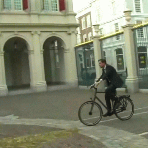 a man riding his bicycle in the middle of town