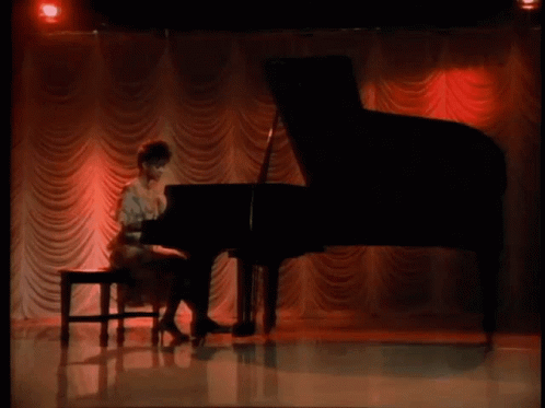 a person is playing on a grand piano