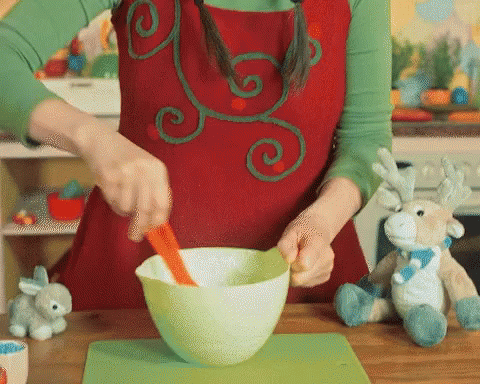 a woman prepares a bowl in a blue apron