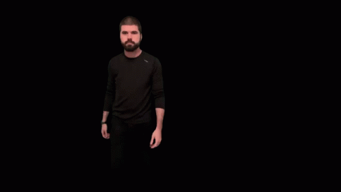 a man with a beard standing in the dark