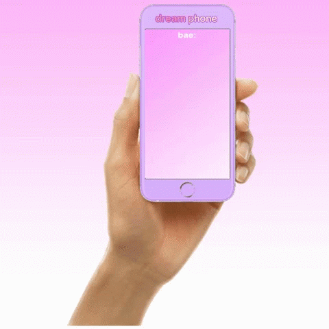 a hand holding a pink cell phone in front of a pink background
