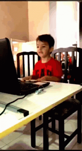  sitting at a table using a computer