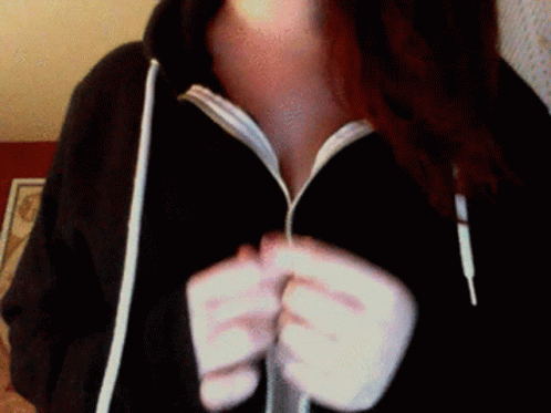 a woman with a hoodie is holding up her fingers