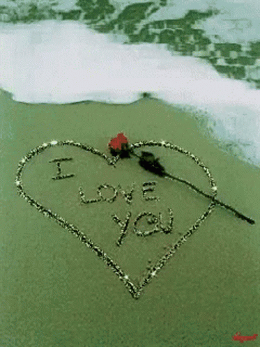 a heart shape drawn on the sand on a beach