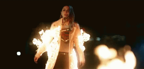a woman wearing a costume made out of fire and some white balls