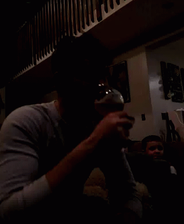 the image of two people drinking beer and playing video games in the dark