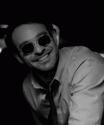 man wearing black and white sunglasses, smiling for the camera