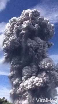 a plume of smoke rising from a large building