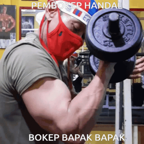 a man in a mask holds up a weight plate