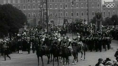 an olympic parade in a city street with horses