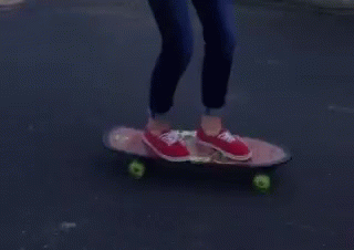 the feet of a person with purple shoes on a skateboard