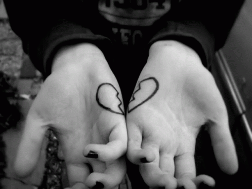 two children's hands holding each other with small hearts