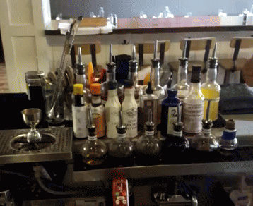 a large group of bottles sitting on top of a metal counter