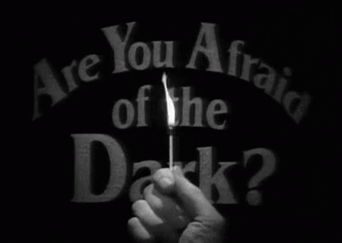 a hand holding a match with the text are you afraid of the dark?
