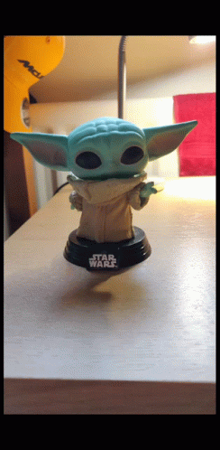 a star wars yoda doll is on top of a desk