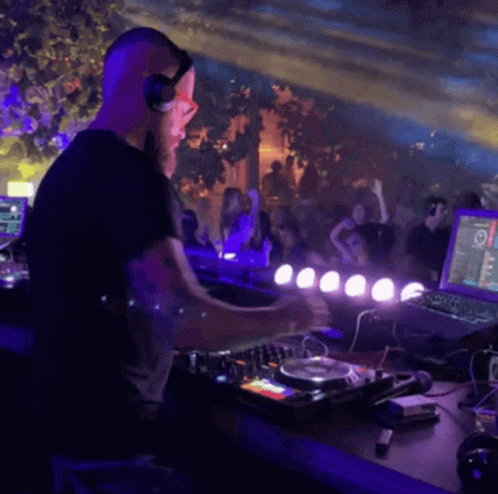 a dj performing on top of a wooden bar