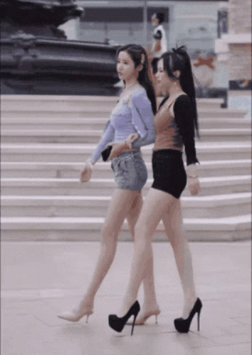 two woman in tight outfits walking up stairs