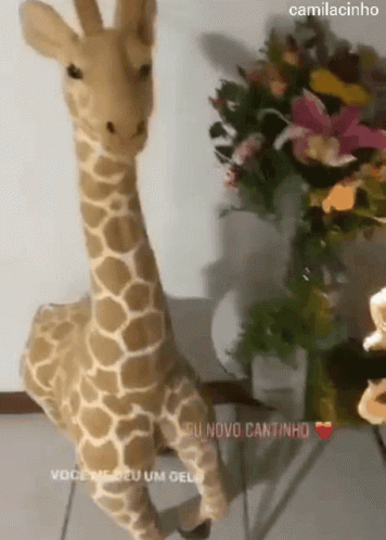 a giraffe stuffed animal next to flowers and a bouquet