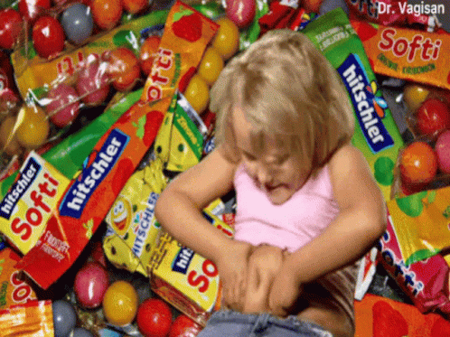 a child plays in a pile of candy
