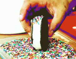 a person picking up a cookie from an oven with sprinkles