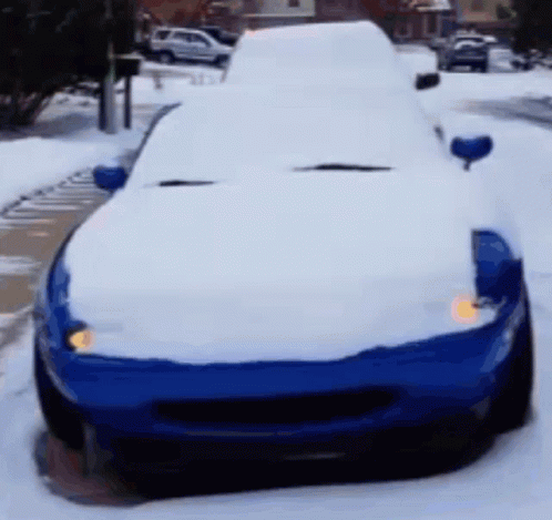 a car covered in snow on the street