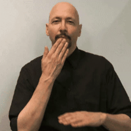a man is standing while holding his hands in his mouth