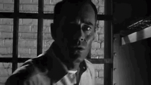 a man with his face slightly in a prison cell