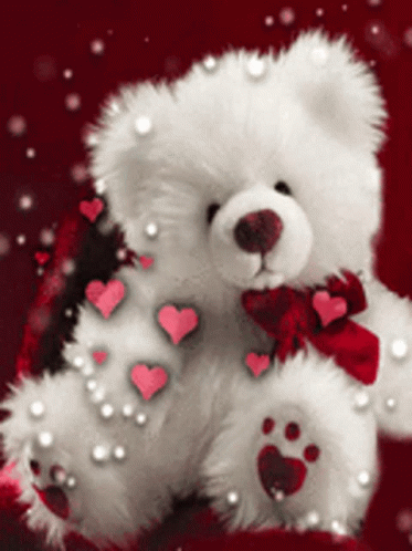 a white teddy bear holding a blue heart
