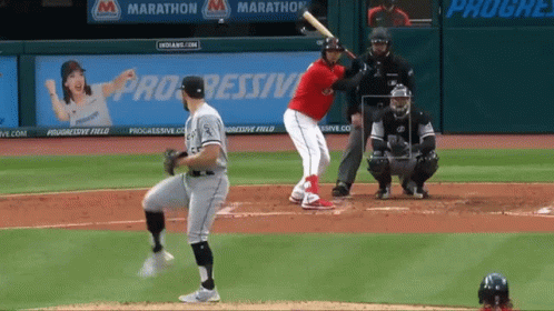 baseball player swinging bat during game, with catcher and umpire on far side