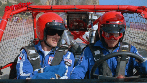 two people with helmets and goggles sitting in a car