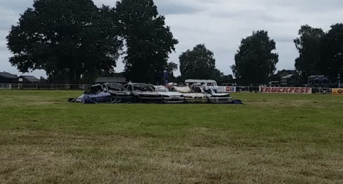 several cars are piled up in a large field
