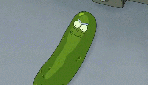 a green pickle with one eye open and a pair of scissors in front
