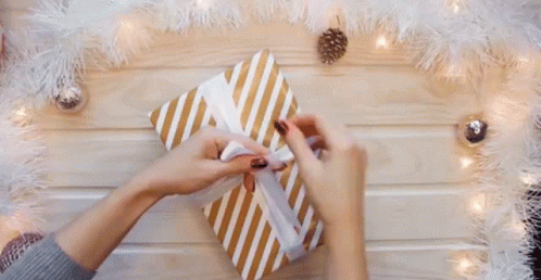 someone wrapping a gift in white feathers with blue and silver