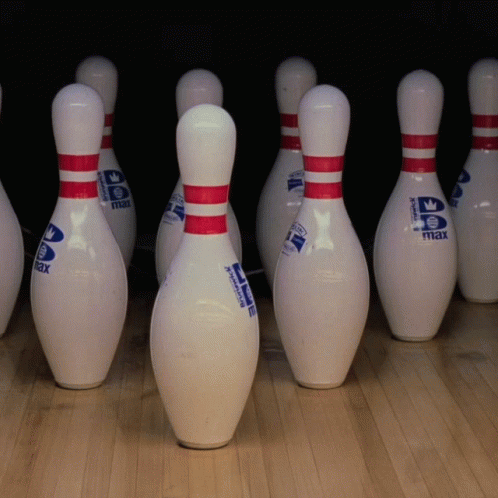 some bowling balls in a line on a hard wood floor